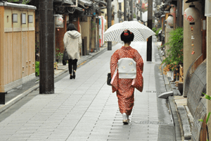 Frau im rotem Kimono mit großem weißen Obi auf Japanischer Straße