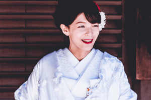 Lächelnde Frau in Weißem Kimono mit Haarschmuck
