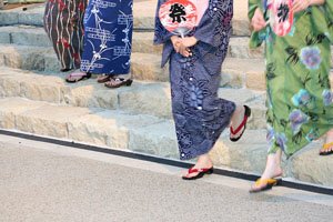 Drei frauen im Kimono die eine Treppe runterlaufen.