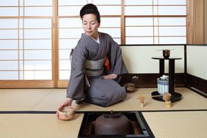 Frau mit einem Iro Muji Kimono bei einer Teezeremonie.