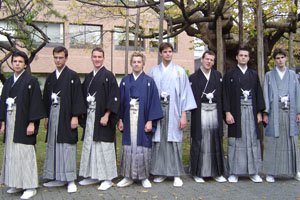 Eine Gruppe von jungen männern vor einer art schule mit traditionellen Kimonos und Haori.